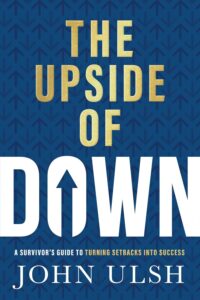 Upside Down book cover showing bold title "The Upside of Down" by John Ulsh, with a dark blue background and upward-pointing arrows, emphasizing resilience, success, and turning setbacks into opportunities.