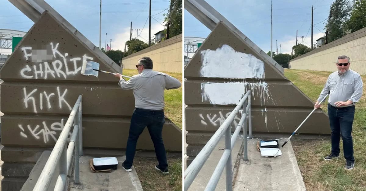 Graffiti removal of spray paint on concrete wall, man painting over graffiti with white paint, patriotic setting with American flags, community cleanup effort on America Out Loud News.