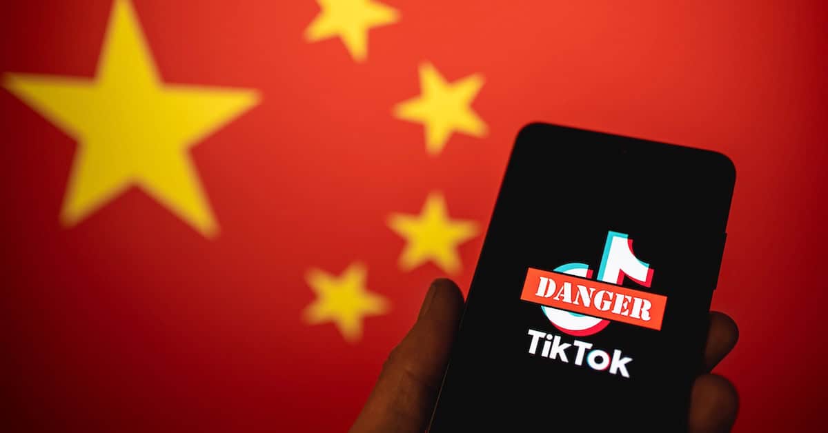 China flag in the background with a smartphone displaying a TikTok warning label about danger, highlighting concerns over social media safety and international digital security.