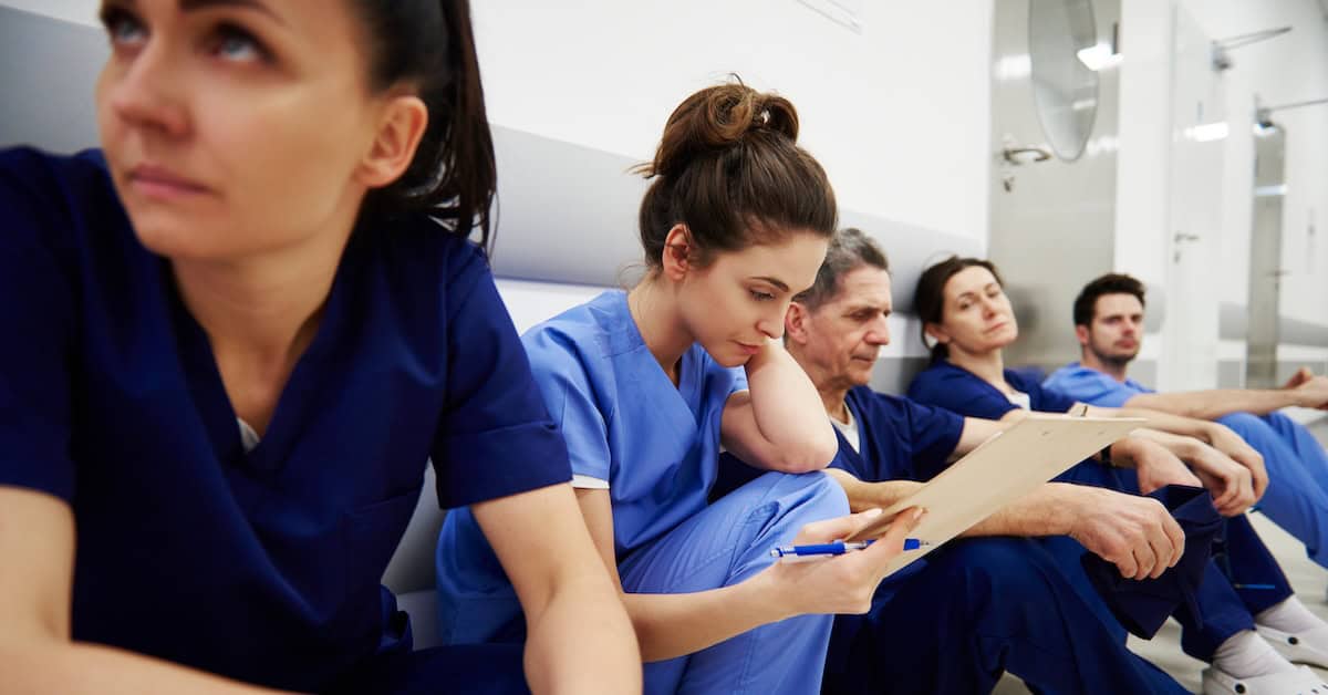 Female nurse examining medical records in the corridor