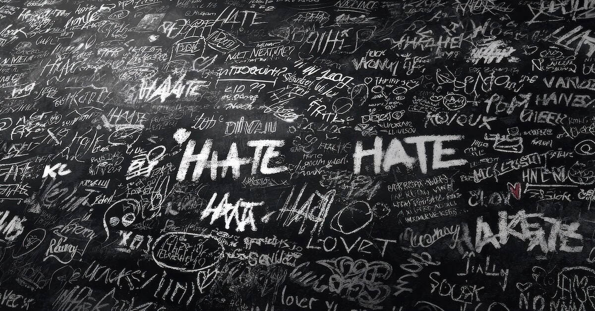 Hate speech chalkboard with various words and doodles, black background, white and red markings, social commentary on negative emotions, graffiti style, art illustration, activism, protest themes, American news coverage relevance.