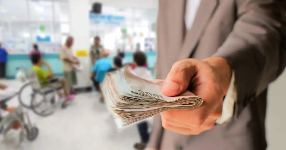 Businessman give many money for insurance with blurred of people in hospital