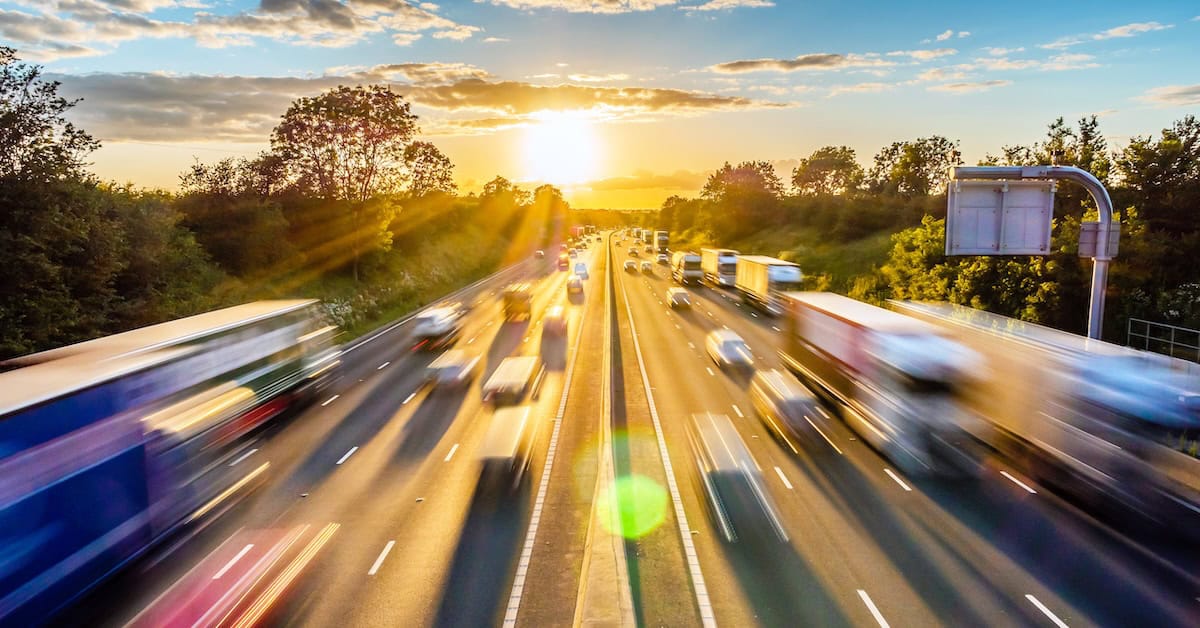 heavy traffic moving at speed on UK motorway in England at sunset.